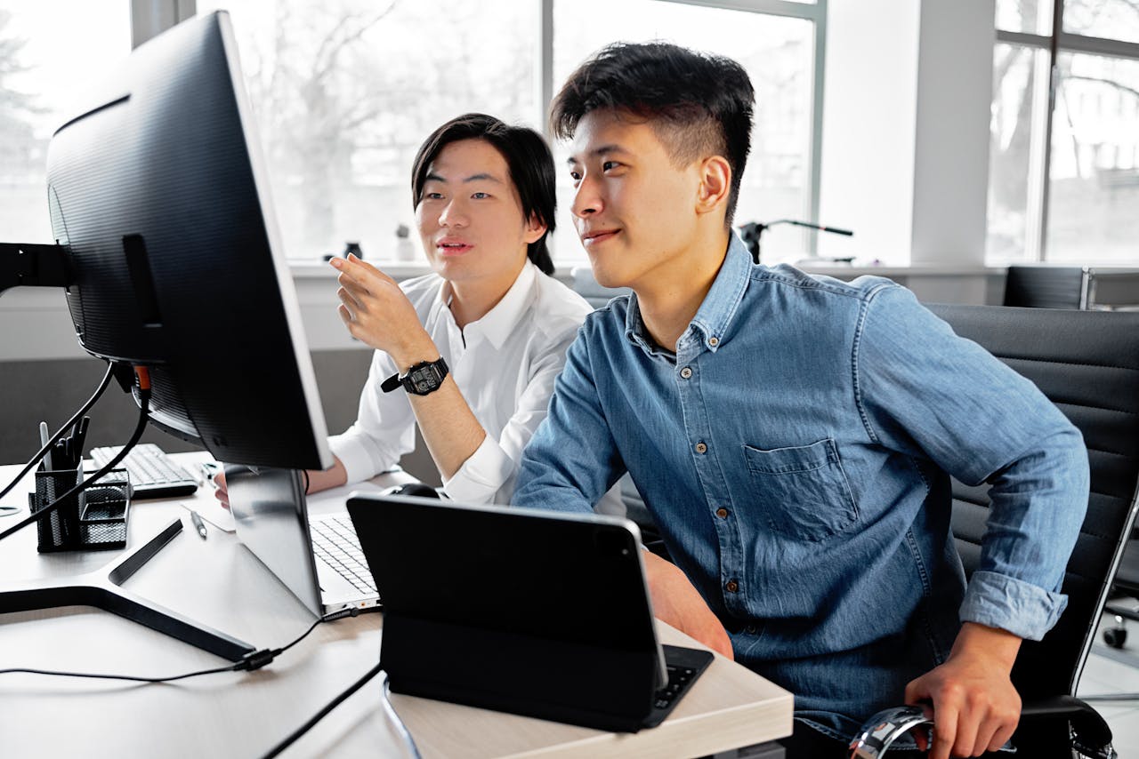 Employees Sitting on Swivel Chairs while Looking at the Monitor